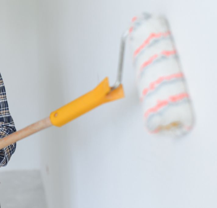 Bluff City Exteriors employee painting a wall